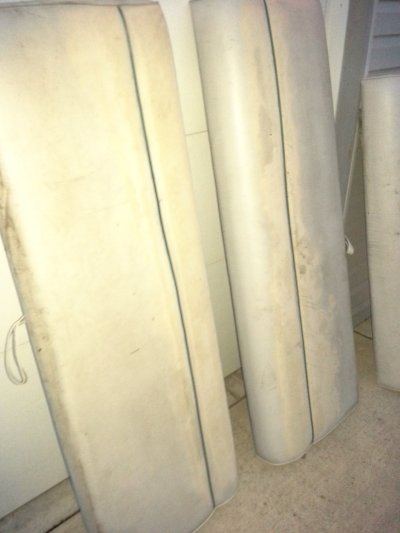 Three off-white boat seats leaning against a wall.